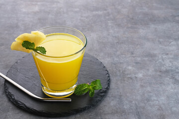 A glass of fresh pineapple juice with mint leaf and slice fruit. Cold Pressed Juice