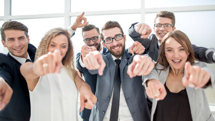 close up. smiling business team pointing at you.