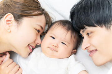 赤ちゃんを見守る両親　子育てイメージ