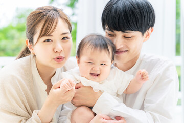 笑顔の赤ちゃんと両親　子育てイメージ
