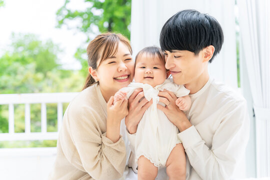 笑顔の赤ちゃんと両親　子育てイメージ