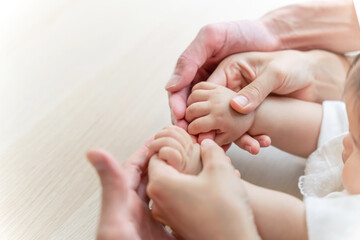手を取り合う赤ちゃんと家族　ファミリーイメージ