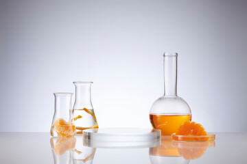 Front view of orange decorated with glassware and transparent podium in white background	