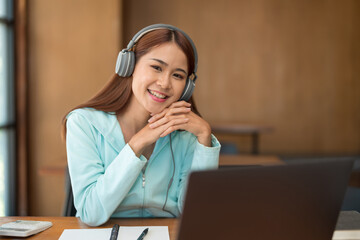 College education concept, Teenage girl wear headphone and watch video tutorial of tutor on laptop