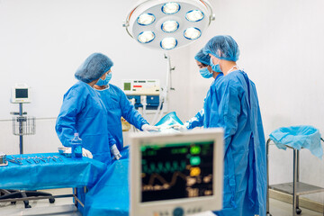 Professional anesthesiologist doctor medical team and assistant preparing patient to gynecological surgery performing operating with surgery equipment in modern hospital operation emergency room