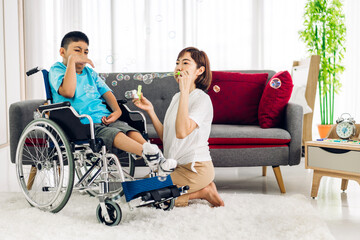 Portrait of asian physiotherapist carer helping and playing with disabled child health problem by doing exercises in rehabilitation clinic.disability care concept