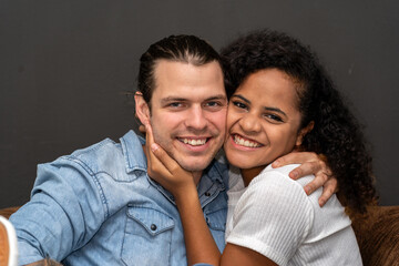 Obraz premium Romantic young happy couple caucasian man and african american woman smile and have fun together in valentine day on black background