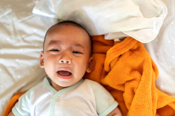 Portrait of happy smile asian baby boy relaxing looking at camera.Cute asian newborn child on the bed at home