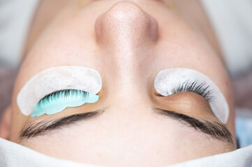 Close-up portrait of a woman in a beauty salon on eyelash lamination procedure. 