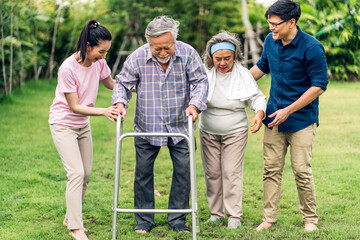 Portrait enjoy happy smiling love multi-generation asian big hug family.Senior mature father and elderly mother with young adult woman and son outdoor in park at home.insurance concept