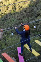 Group of people crossing a TIBETAN BRIDGE, tourist attraction in San Mateo de Otao - Peru.