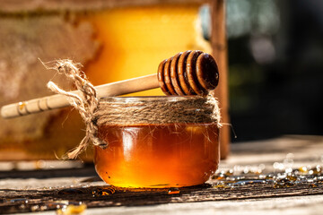 Natural honey comb and a glass jar on wooden table. Honey background. bee products by organic...