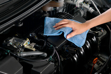 Fototapeta na wymiar hand of a man holding a blue cloth caring, maintenance car and cleaning And engine car room