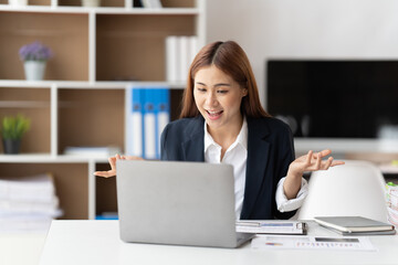 Young attractive business asian woman talking about sale report in video call conference on notebook computer online meeting in working from home.