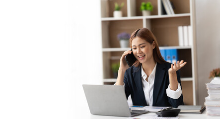Asian businesswoman in formal suit in office happy and cheerful during using smartphone and working, copy space.