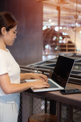 Casual Businesswoman using smartphone and laptop, freelance woman typing keyboard computer notebook in cafe or modern office. technology, digital online and network concept