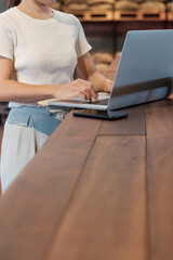 Casual Businesswoman using laptop, freelance woman typing keyboard computer notebook in cafe or modern office. technology, digital online and network concept