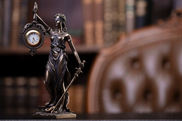 Judge office. Themis sculpture and gavel on the judge desk. Book shelf and judge chair in the background.