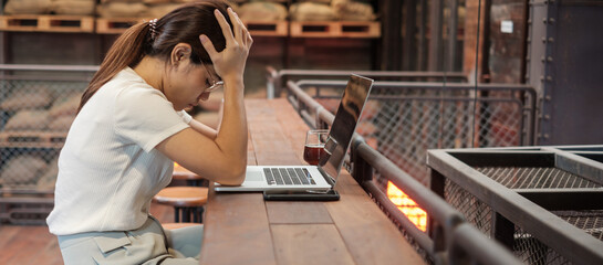 Casual businesswoman serious and concerned with laptop computer, asian woman stressed and tired...