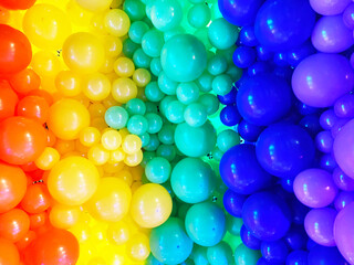Fototapeta premium Bright abstract background of jumble of rainbow colored balloons celebrating