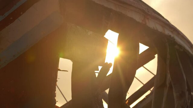 Golden Hour Beach Sunset Sunlight Shining Through Old Fishing Boat Remains. 