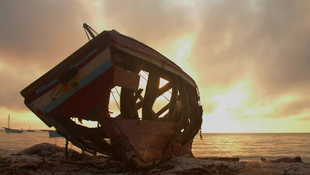 Silhouette Of Old Fishing Boat Remains Sitting On African Coast During Beautiful Warm Golden Hour Beach Sunset. Vilanculos Bazaruto Archipelago, Mozambique, Africa.