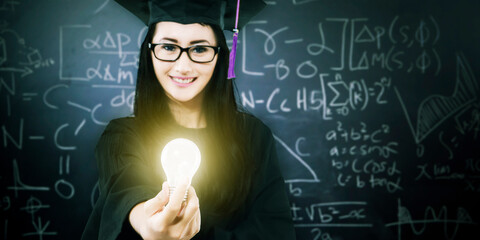 Female graduate student holding a bulb in class