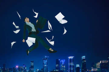 Happy businesswoman jump with papers in night city