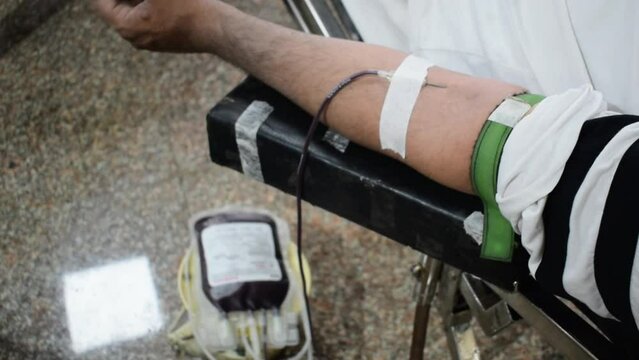 Blood donor at Blood donation camp held with a bouncy ball holding in hand at Balaji Temple, Vivek Vihar, Delhi, India. Also concept image for World blood donor day on June 14 every year