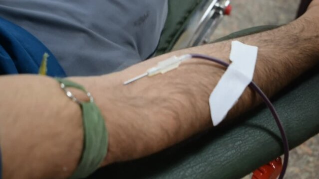 Blood donor at Blood donation camp held with a bouncy ball holding in hand at Balaji Temple, Vivek Vihar, Delhi, India. Also concept image for World blood donor day on June 14 every year