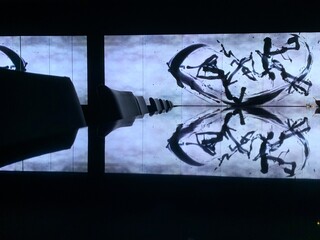 おしゃれラーメン店 teamLab スクリーンに映る抽象的な映像とその映像を反射するテーブル