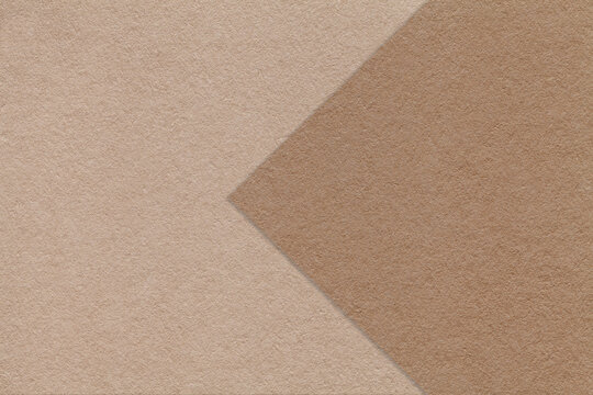 Texture of beige and brown paper background, half two colors with arrow, macro. Structure of dense craft cardboard.