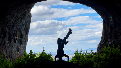 The concept of the man in the handstand position in the historical cave and the lifestyle in nature