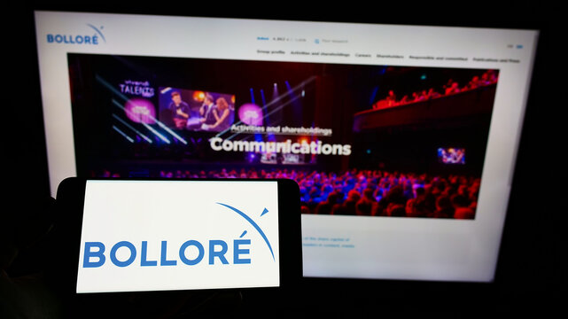 Stuttgart, Germany - 02-06-2022: Person holding mobile phone with logo of French conglomerate company Bollore SE on screen in front of business web page. Focus on phone display.