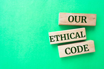 Our ethical code words on wooden blocks on green background.