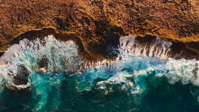 Aerial video of waves crushing on the red rocks, quobba station, red bluff in Western Australia 