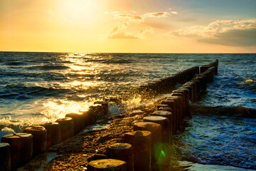 Buhnen am Strand von Zingst bei Sonnenuntergang führen in die Ostsee