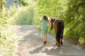 Icelandic horse on gravel road with young woman. Shot in the evening middle of the summer in Finland