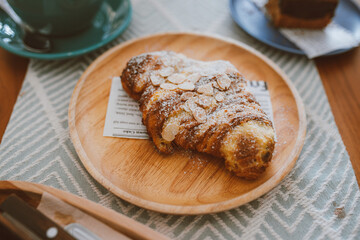 Croissants with nuts flakes crumbs and coffee on the table in the cafe, Delicious breakfast morning, Cafe tone color, Selective focus.