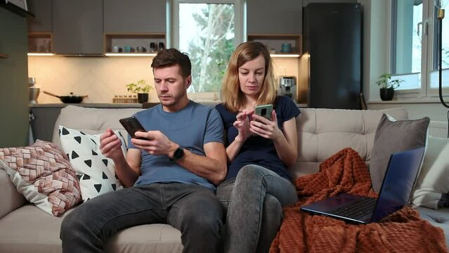Family couple sitting on sofa in living room and using smartphones, Family leisure weekend, Spending time together
