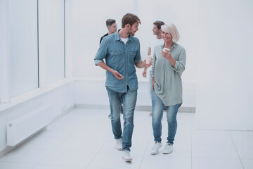 Fototapeta premium employees with coffee glasses passing through the corridor of the office