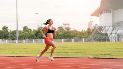 Obraz premium woman running during sunny morning on stadium track