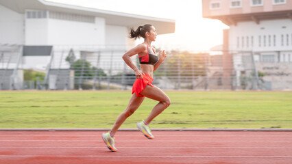 woman running during sunny morning on stadium track