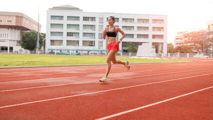 Obraz premium woman running during sunny morning on stadium track