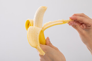 バナナの皮を剥く手元　banana - obrazy, fototapety, plakaty