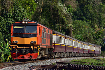 Obraz premium Thai passenger train by diesel locomotive on the railway.