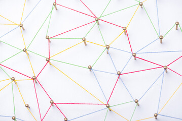 abstract web line connection of color yarn from nail node to node on white background , networking...