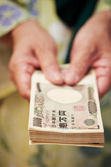 A hand holding Japanese money, one million yen