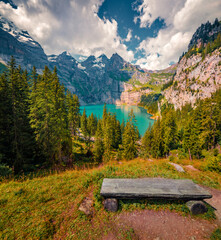 Empty sit on the shore of unique Oeschinensee Lake. Sunny morning scene of Swiss Alps with...