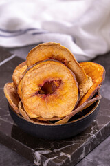 Dried peach slices. Sliced dried peaches on a dark background. Sun-dried fruit. Close-up.